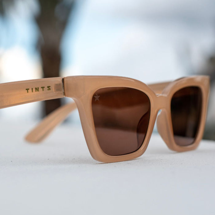 Luci Tan by TINTS Eyewear. Glossy beige frame, brown Lenses